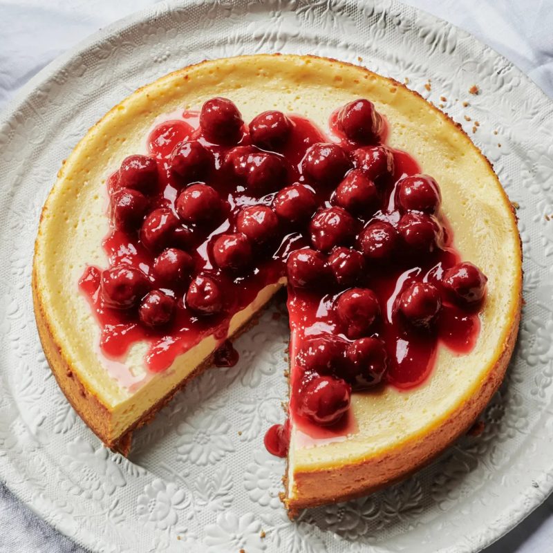 Cheesecake od višanja s bogatim sočnim preljevom od višanja na keramičkom tanjuru